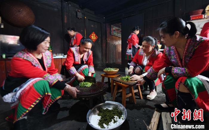 3月14日，在广西桂林市龙胜各族自治县马堤乡马堤村民合瑶寨，村民将艾草磨碎后加入糯米粉。　潘志祥 摄