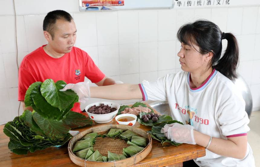 两名村民在包“桐叶粑”。三江侗族自治县融媒体中心供图