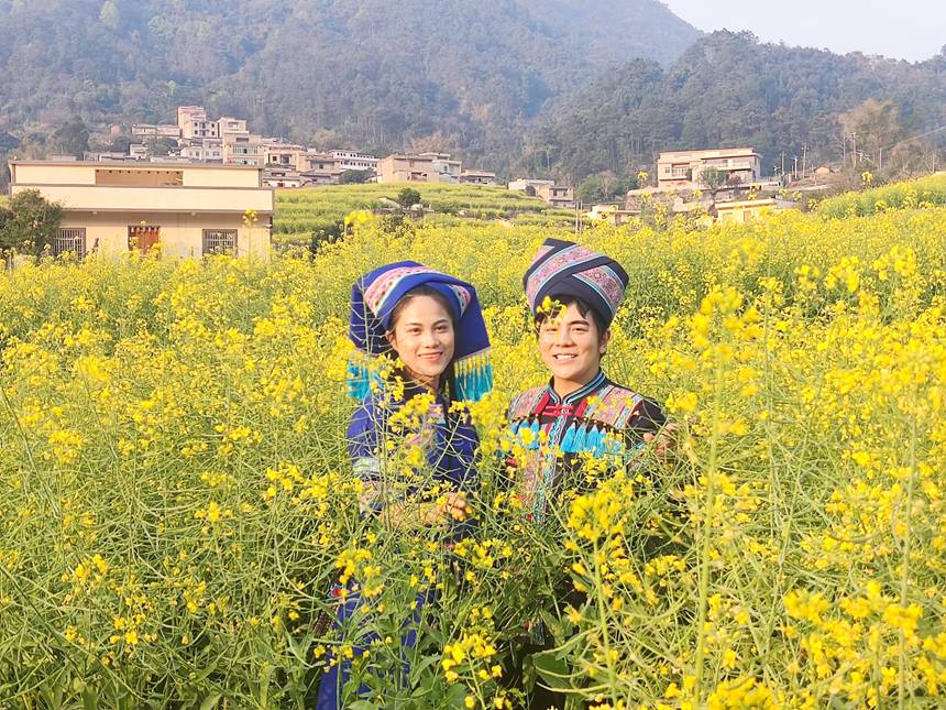 游客在油菜花地里拍照留念。人民网记者 王勇摄