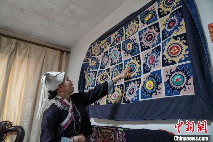 黄碧瑜将背带的主要图案，缝制在一张床单上展示。　王以照 摄