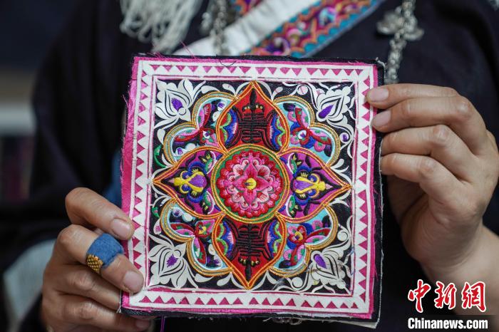 黄碧瑜正在缝制的图案，“石榴花”位列中央，上下绣着“寿”字，蝴蝶围绕外围，寓意长命百岁。　王以照 摄