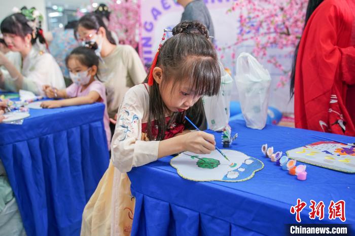 图为儿童身着汉服学习画团扇。　陈冠言 摄