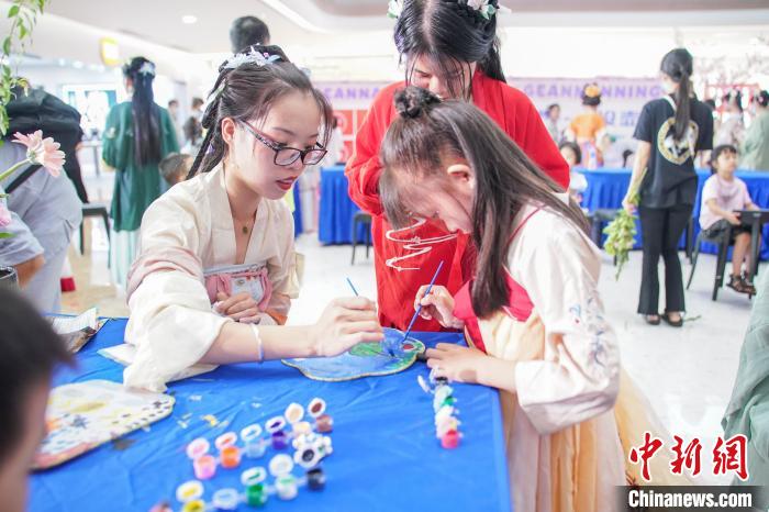 图为广西南宁汉服爱好者身着传统服饰学习画团扇。　陈冠言 摄