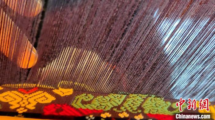 图为“织女”们用竹笼机织壮锦。 张广权 摄 图为“织女”们用竹笼机织壮锦。 张广权 摄