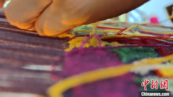 图为“织女”们用竹笼机织壮锦。 张广权 摄 图为“织女”们用竹笼机织壮锦。 张广权 摄