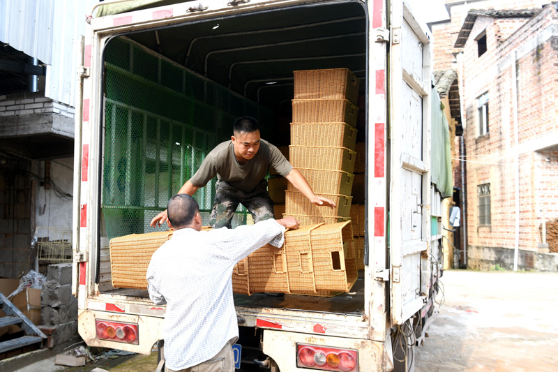村民把藤编工艺品装车准备外运
