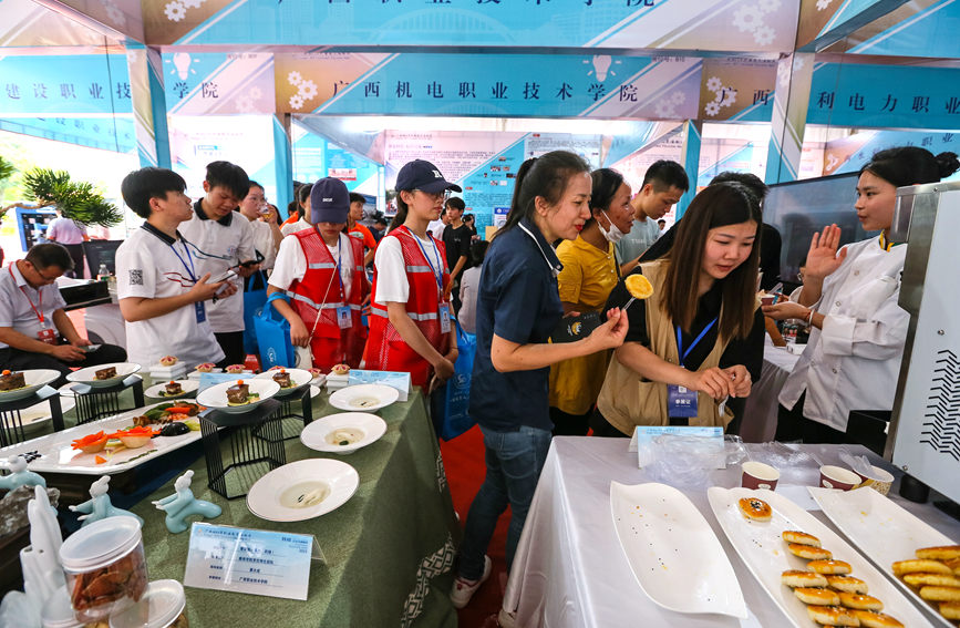 广西职业技术学院展示的药膳、酥饼吸引观众争先品尝。罗仁维摄