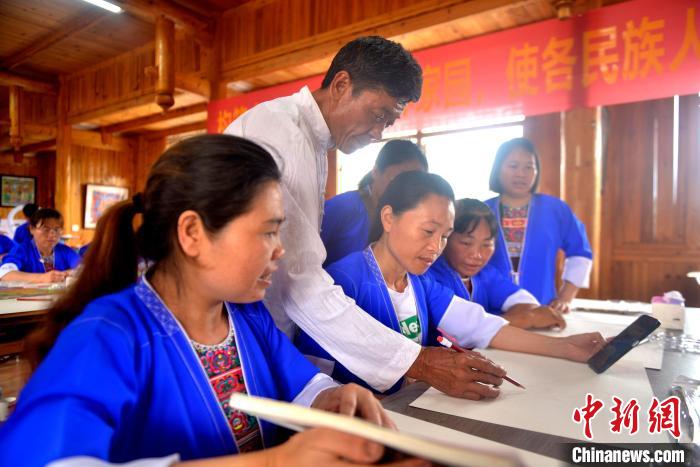 图为农民画老师指导学员构图。 滚亿忠 摄