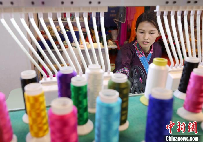 1月4日，一名绣娘在广西三江侗族自治县古宜镇一家服饰馆生产绣片。龚普康 摄