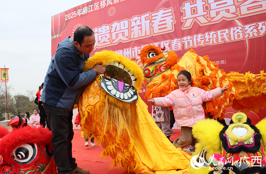 大人引导小孩体验舞彩狮。人民网 付华周摄